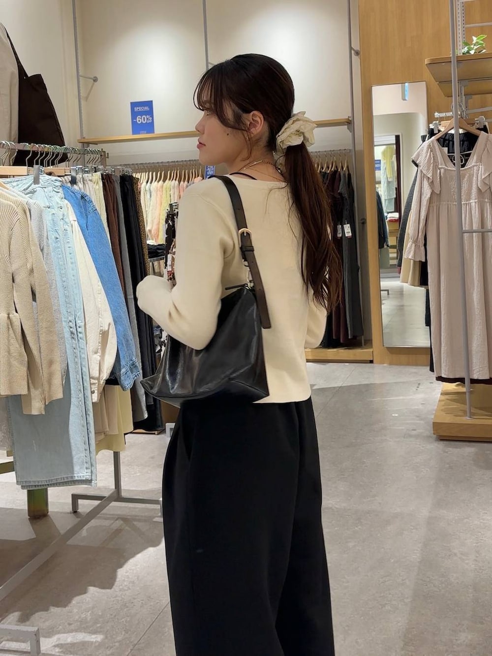 ブラック系のスウェットパンツ、ブラック系のショルダーバッグ、ブラック系のローファーを着用したレディースの春コーディネートの4枚目の写真