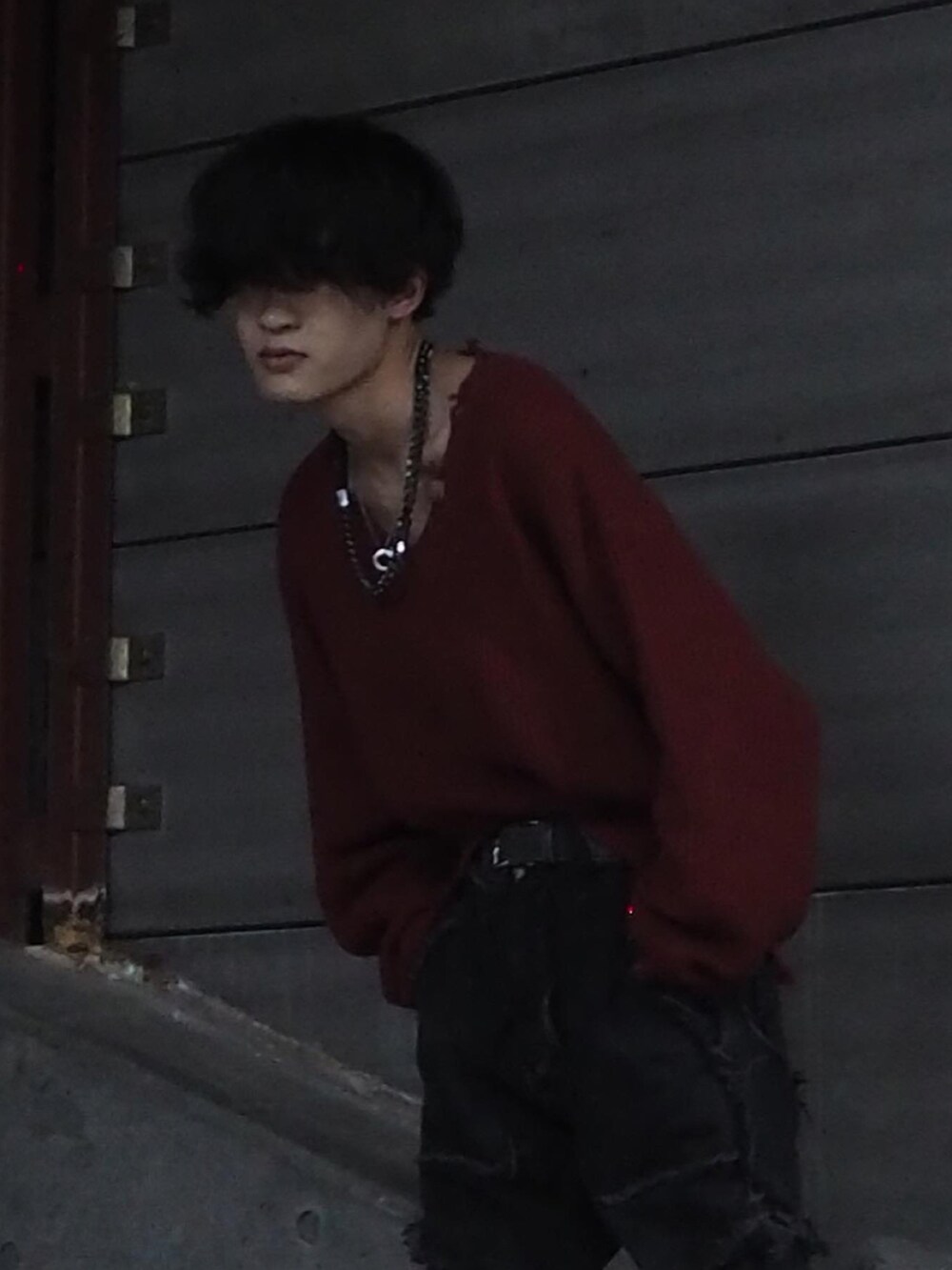 ブラック系のスニーカー、グレー系のデニムパンツ、レッド系のニット/セーターを着用したメンズの秋コーディネートの3枚目の写真