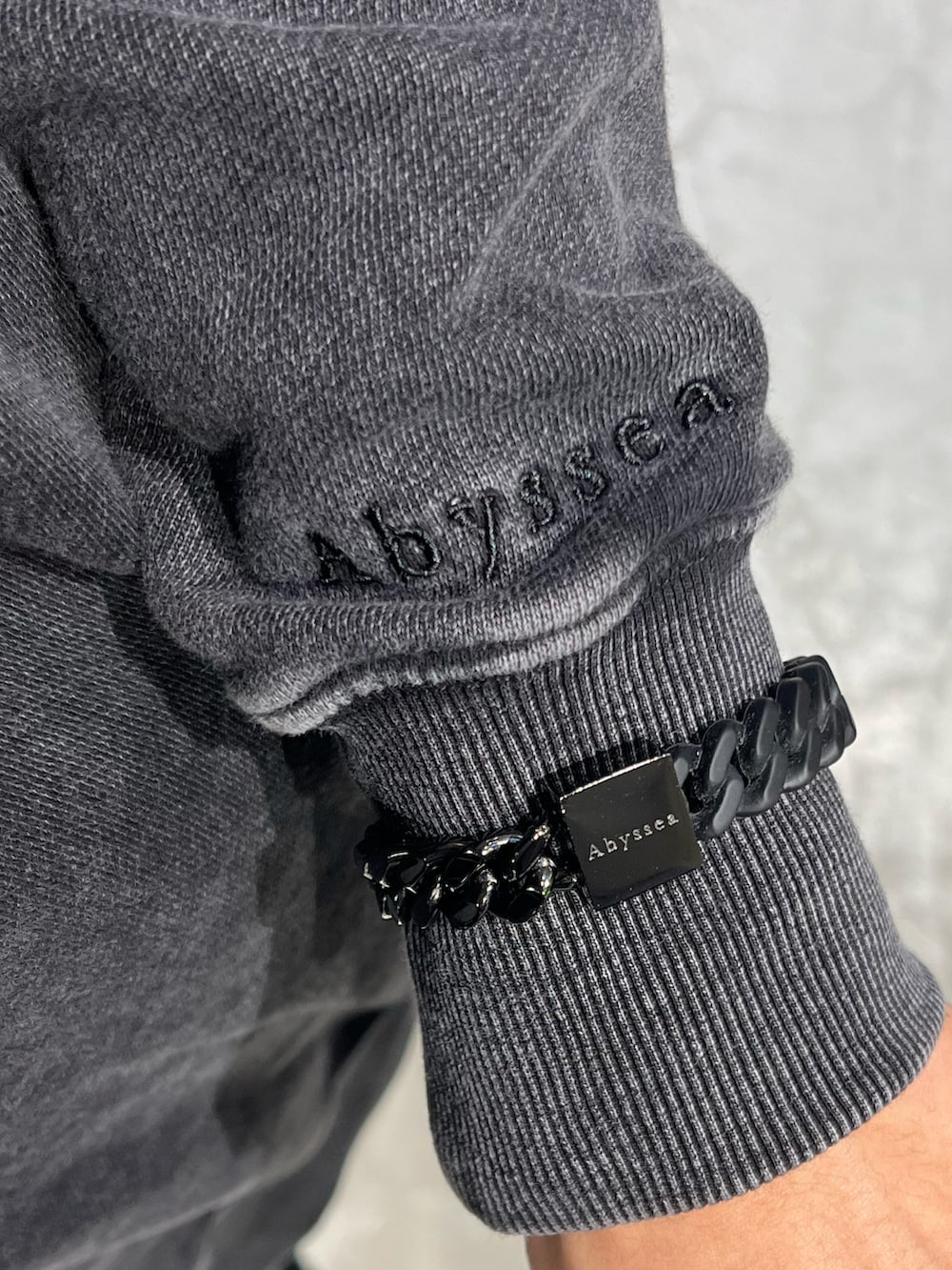 ブラック系のスウェット、ブラック系のカーゴパンツ、ブラック系のスニーカーを着用したメンズの秋コーディネートの3枚目の写真