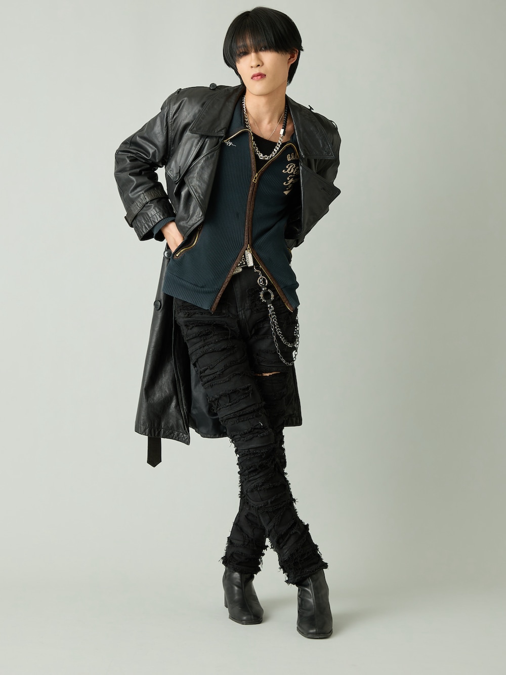 ブラック系のブーツ、ブラック系のデニムパンツ、ブラック系のトレンチコートを着用したメンズの春コーディネートの2枚目の写真