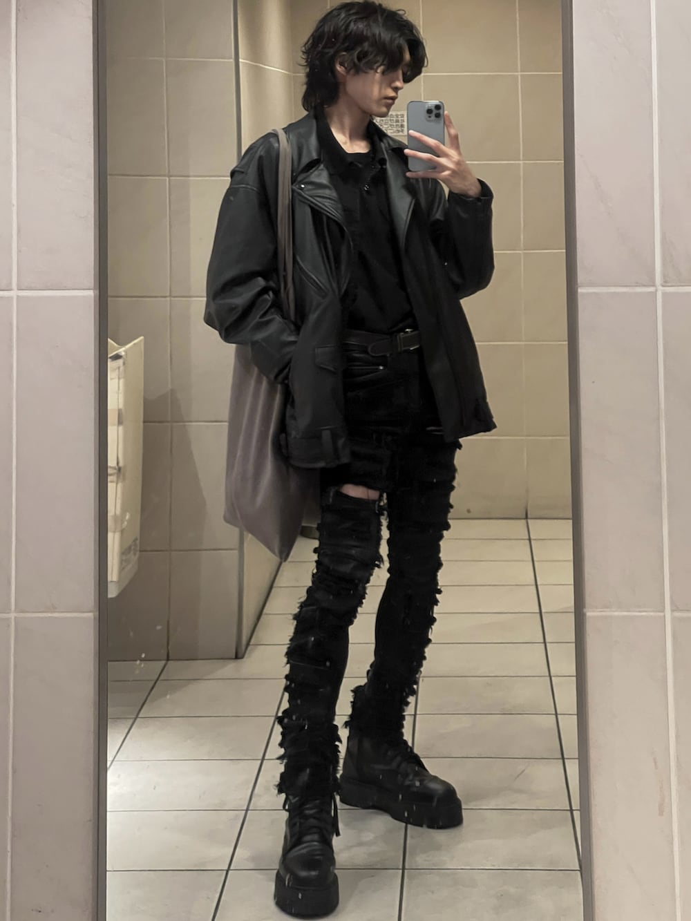 ブラック系のブーツ、ブラック系のTシャツ/カットソー、ブラック系のライダースジャケットを着用したメンズの冬コーディネートの2枚目の写真