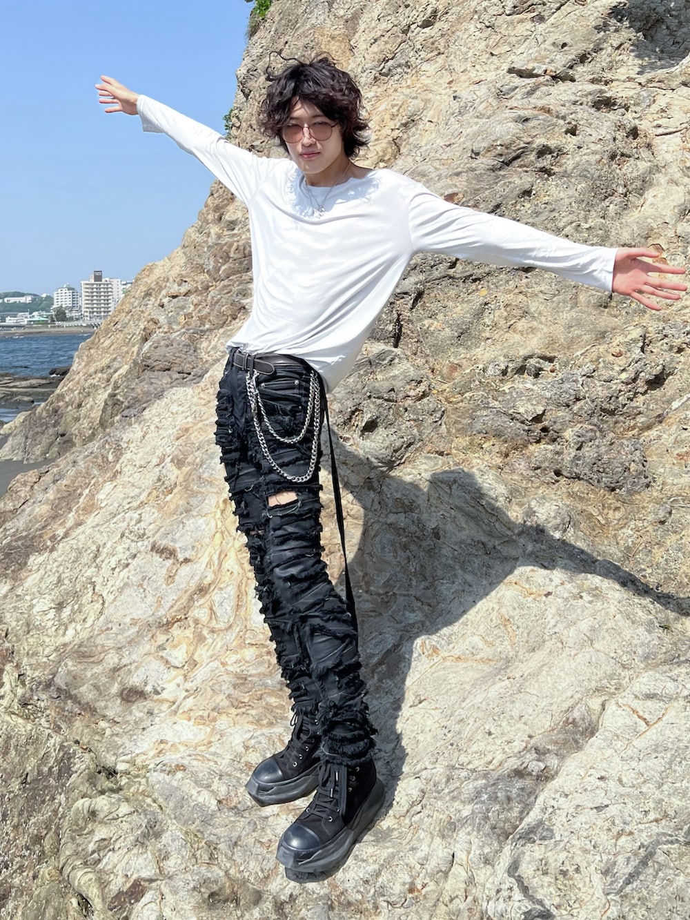 ホワイト系のTシャツ/カットソー、ブラック系のデニムパンツ、ブラック系のスニーカーを着用したメンズの夏コーディネートの2枚目の写真