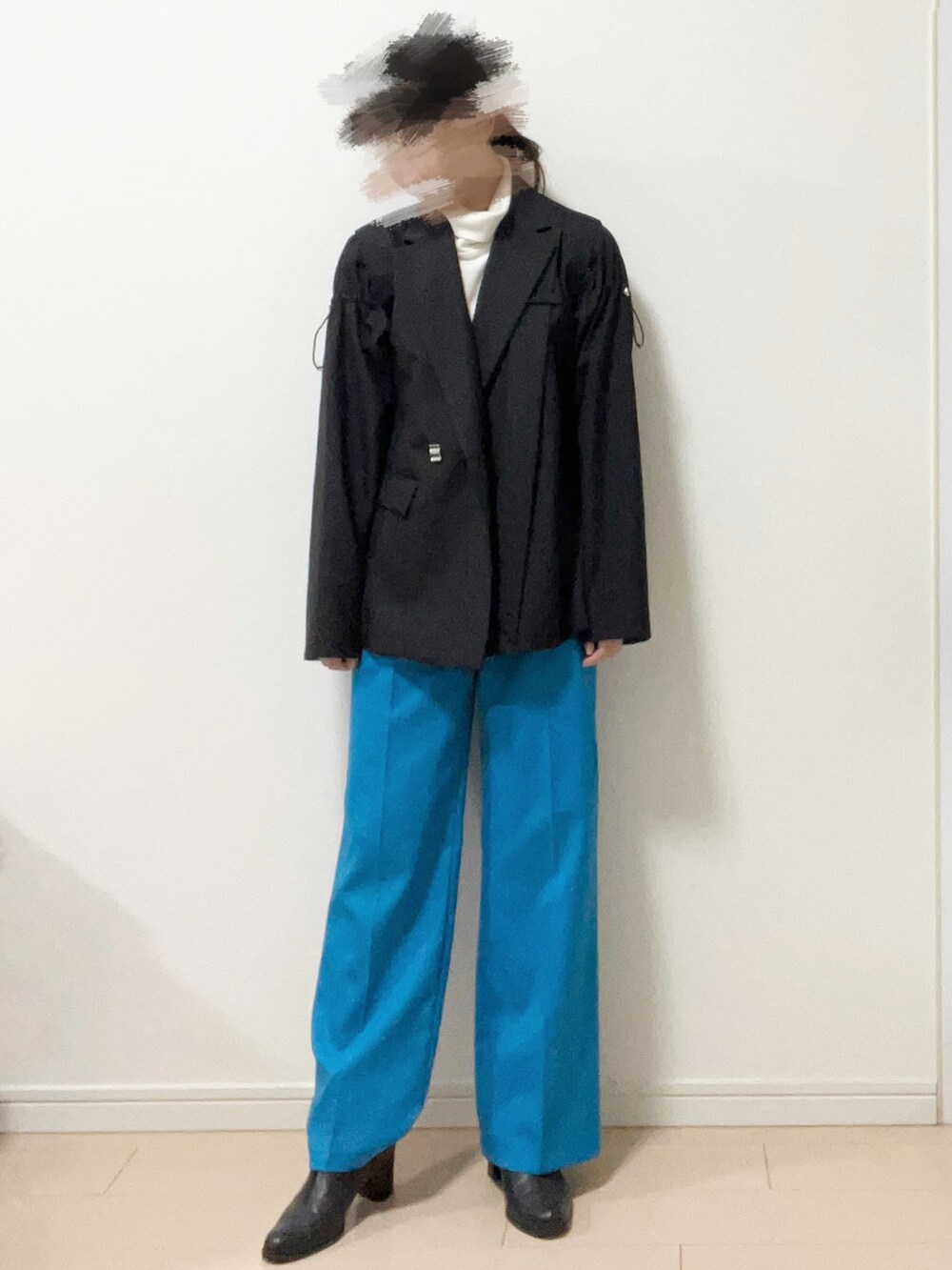 ブラック系のテーラードジャケット、ホワイト系のトップス、ブルー系のその他パンツを着用したレディースの秋コーディネートの2枚目の写真