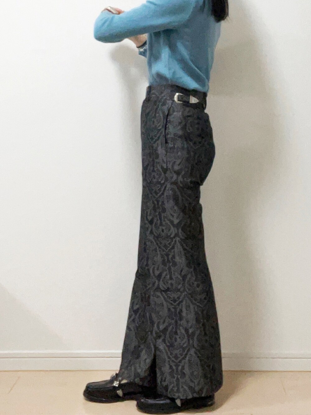 グレー系のスラックス、ブラック系のローファー、ブルー系のニット/セーターを着用したレディースの秋コーディネートの2枚目の写真