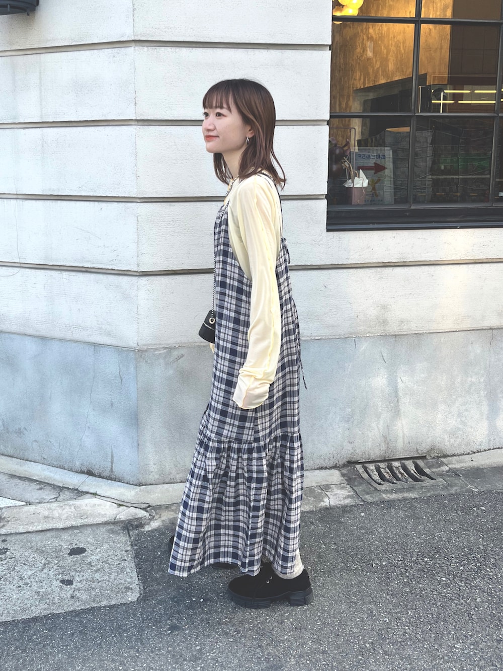 ブルー系のワンピース、ブラック系のモカシン/デッキシューズ、イエロー系のTシャツ/カットソーを着用したレディースの冬コーディネートの2枚目の写真