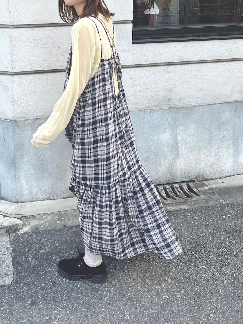 ブルー系のワンピース、ブラック系のモカシン/デッキシューズ、イエロー系のTシャツ/カットソーを着用したレディースの冬コーディネートの3枚目の写真