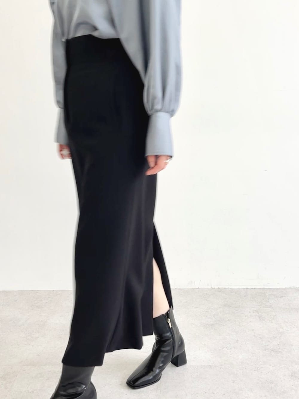 ブルー系のシャツ/ブラウス、ブラック系のスカートを着用したレディースの秋コーディネートの2枚目の写真