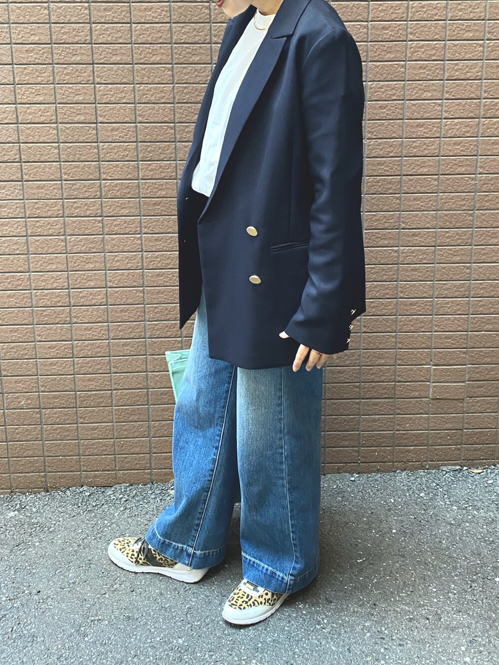 ブルー系のテーラードジャケット、ブルー系のデニムパンツ、ホワイト系のTシャツ/カットソーを着用したレディースの春コーディネートの2枚目の写真