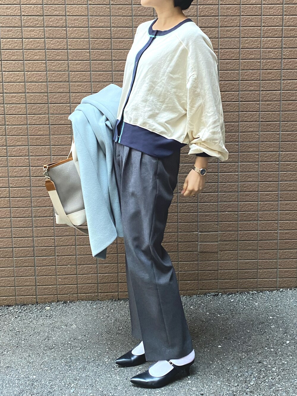 ブルー系のチェスターコート、ホワイト系のカーディガン/ボレロ、グレー系のその他パンツを着用したレディースの冬コーディネートの2枚目の写真