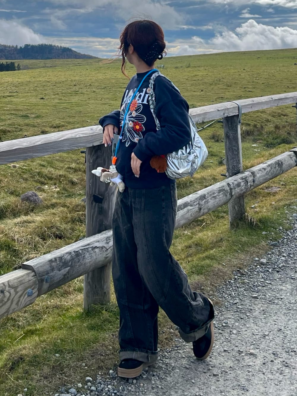 ブルー系のスウェット、ブラック系のスニーカー、ブラック系のデニムパンツを着用したレディースの秋コーディネートの2枚目の写真