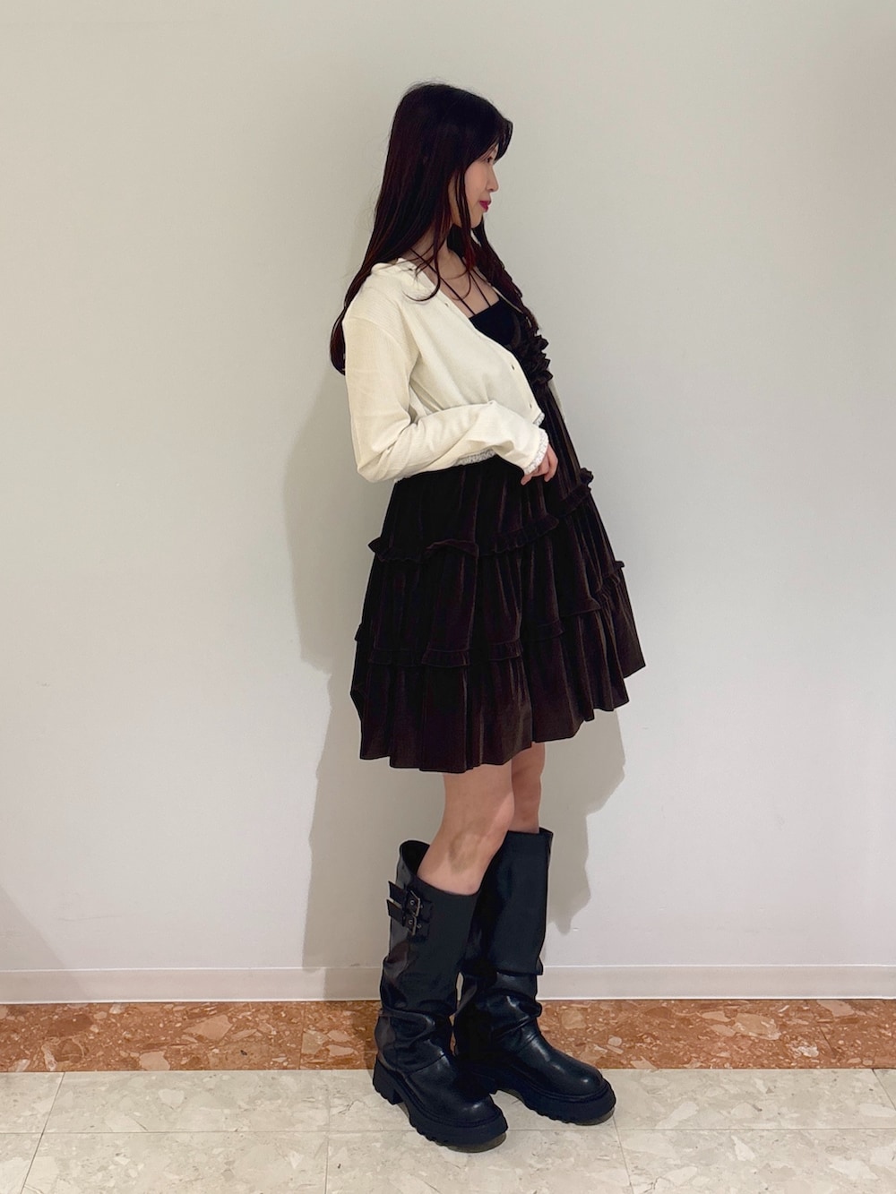 ブラウン系のワンピース、ホワイト系のTシャツ/カットソー、ブラック系のブーツを着用したレディースの秋コーディネートの2枚目の写真