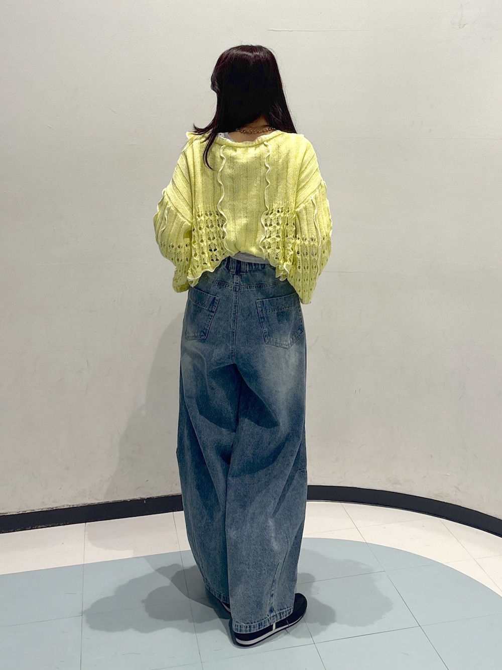 イエロー系のパーカー、ブルー系のデニムパンツを着用したレディースの春コーディネートの2枚目の写真