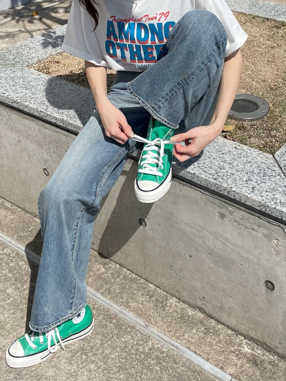 ホワイト系のTシャツ/カットソー、ブルー系のデニムパンツを着用したレディースの春コーディネートの6枚目の写真