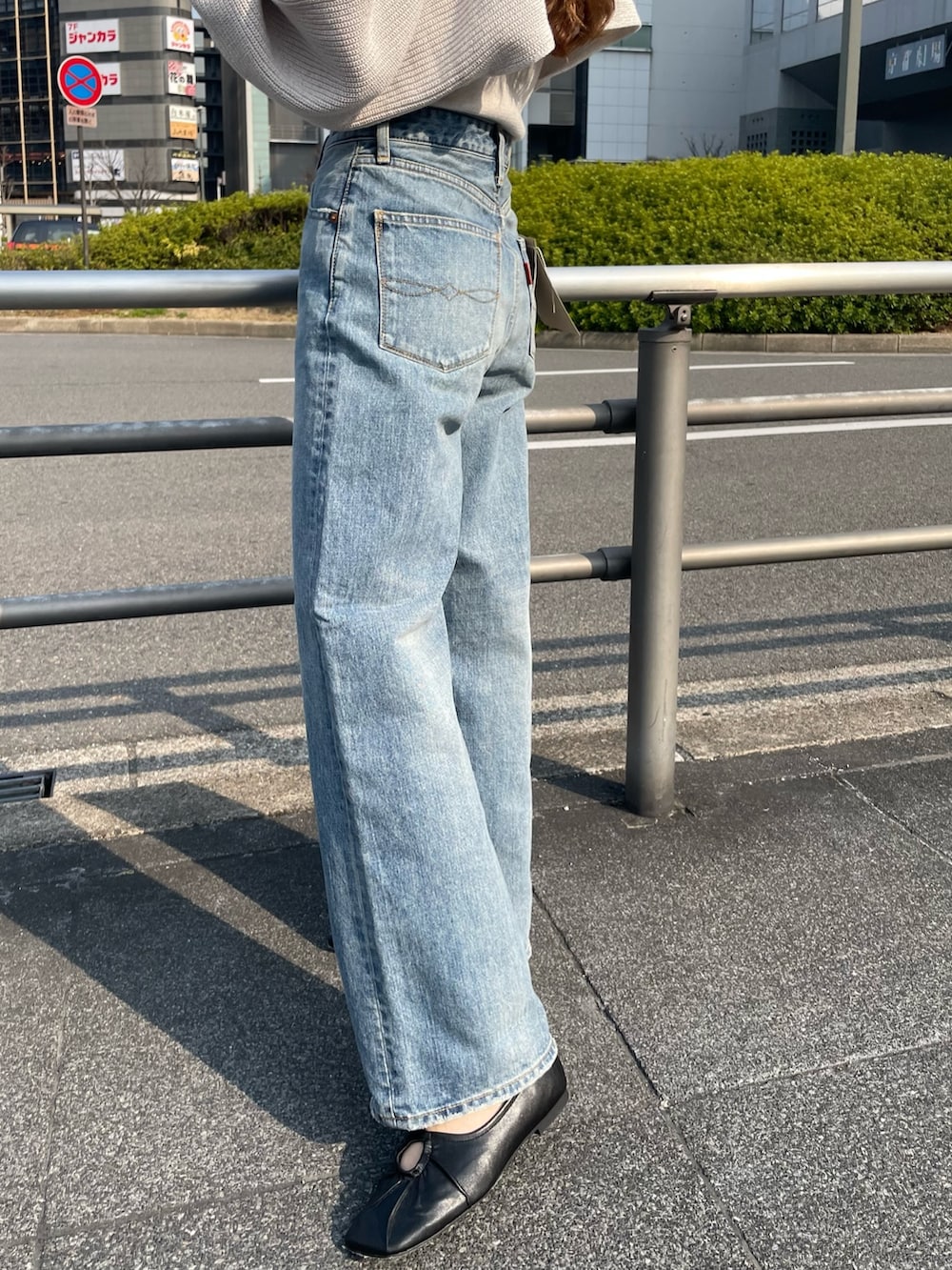 ブルー系のデニムパンツ、ブラック系のパンプス、ホワイト系のニット/セーターを着用したレディースの春コーディネートの6枚目の写真