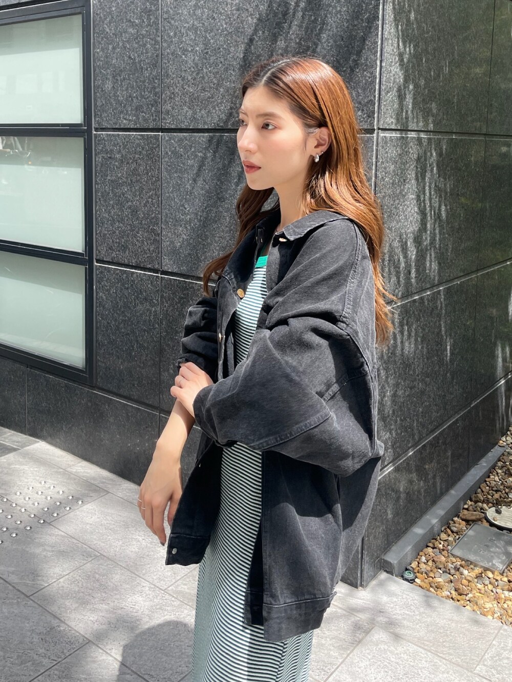 ブラック系のデニムジャケット、グリーン系のワンピースを着用したレディースの夏コーディネートの3枚目の写真