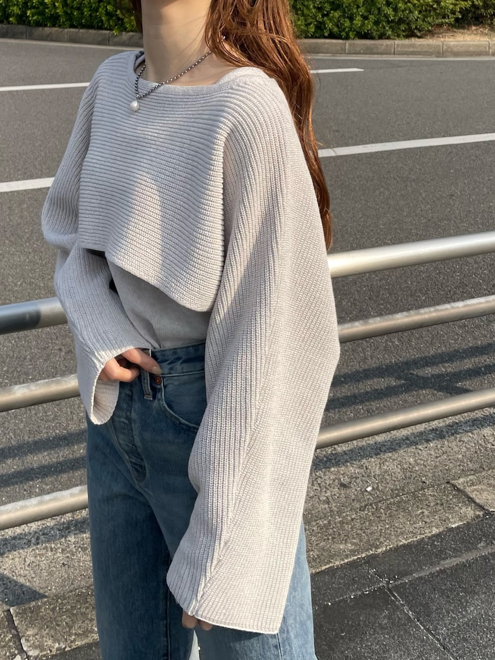 ブルー系のデニムパンツ、ブラック系のパンプス、ホワイト系のニット/セーターを着用したレディースの春コーディネートの5枚目の写真