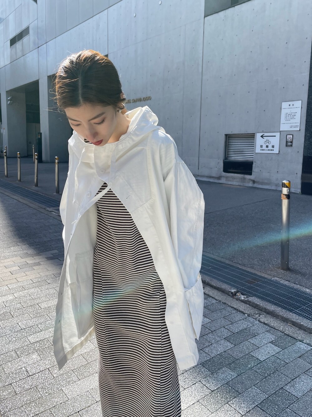 ホワイト系のブルゾン、ブラウン系のワンピースを着用したレディースの春コーディネートの5枚目の写真