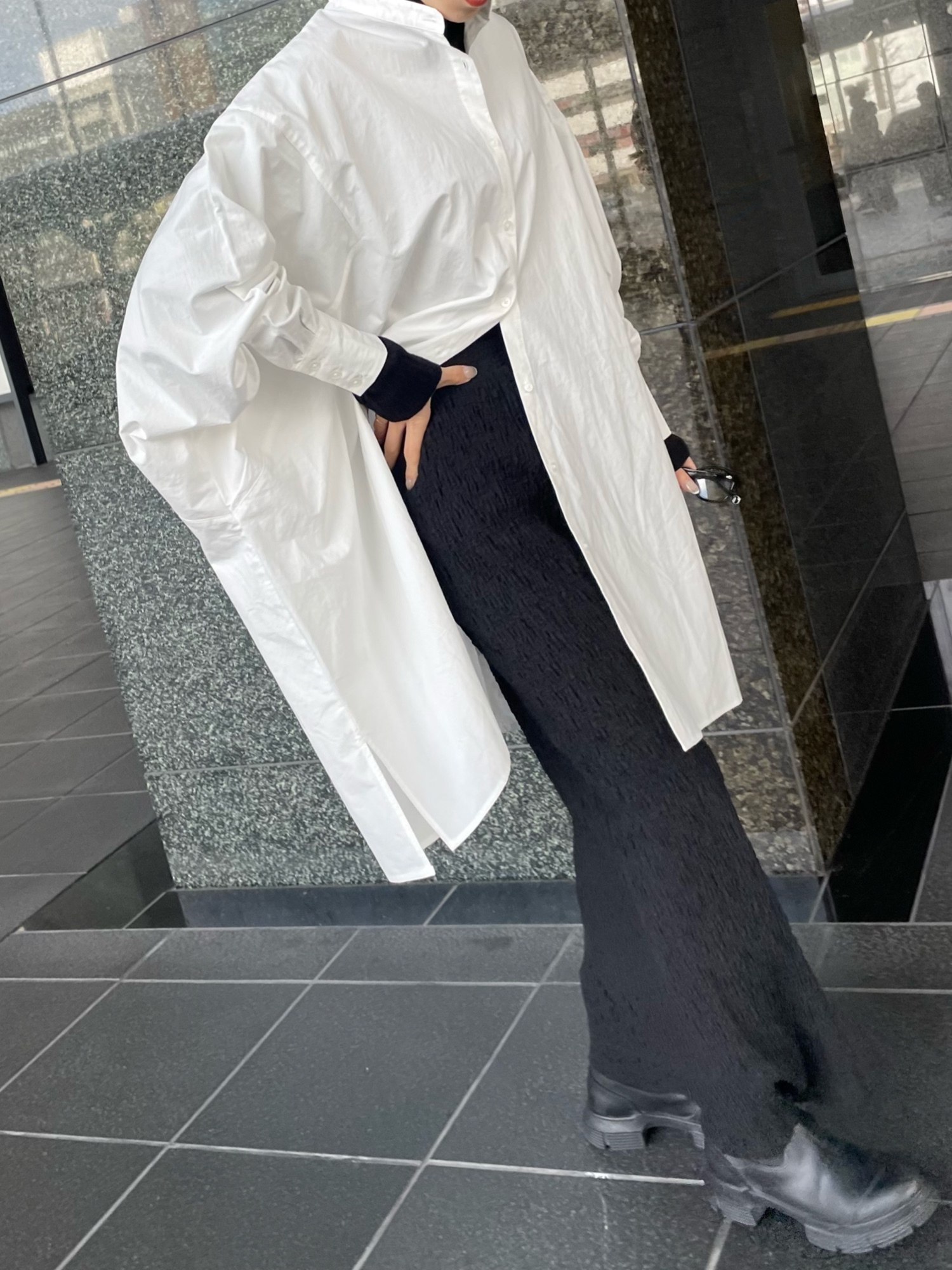 ブラック系のニット/セーター、ブラック系のスカート、ホワイト系のシャツ/ブラウスを着用したレディースの冬コーディネートの5枚目の写真