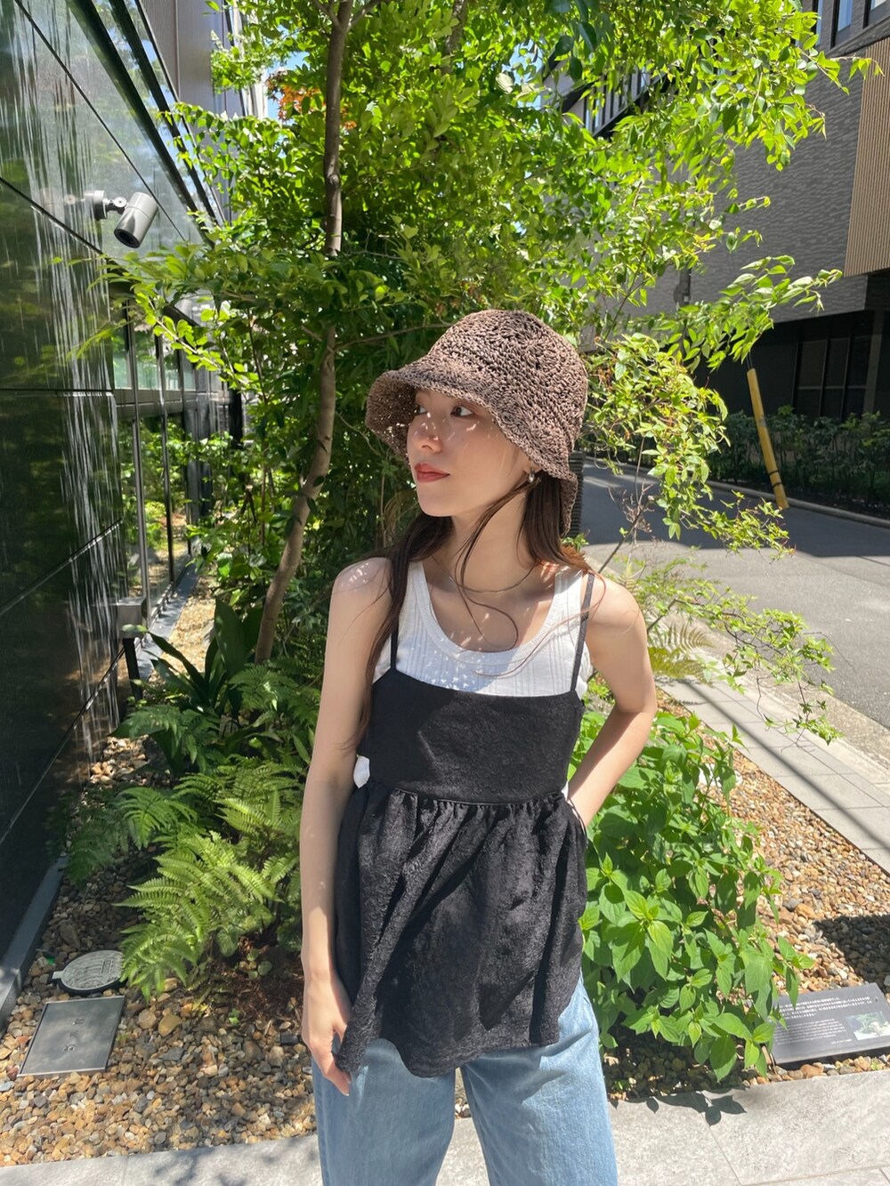 ブラック系のシャツ/ブラウス、ホワイト系のタンクトップ、ブルー系のデニムパンツを着用したレディースの春コーディネートの4枚目の写真