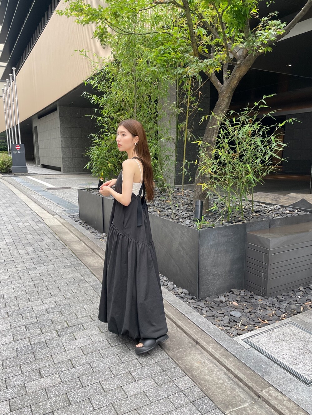ブラック系のワンピース、ホワイト系のキャミソールを着用したレディースの夏コーディネートの2枚目の写真