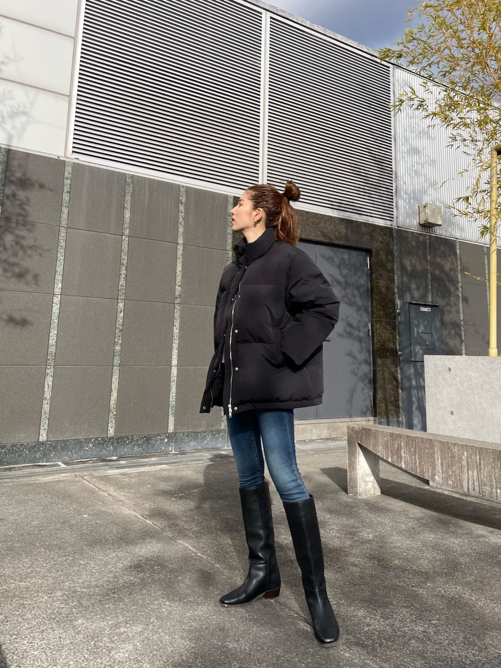 ブラック系のダウンジャケット/コート、ブルー系のデニムパンツ、ブラック系のシューズを着用したレディースの冬コーディネートの4枚目の写真