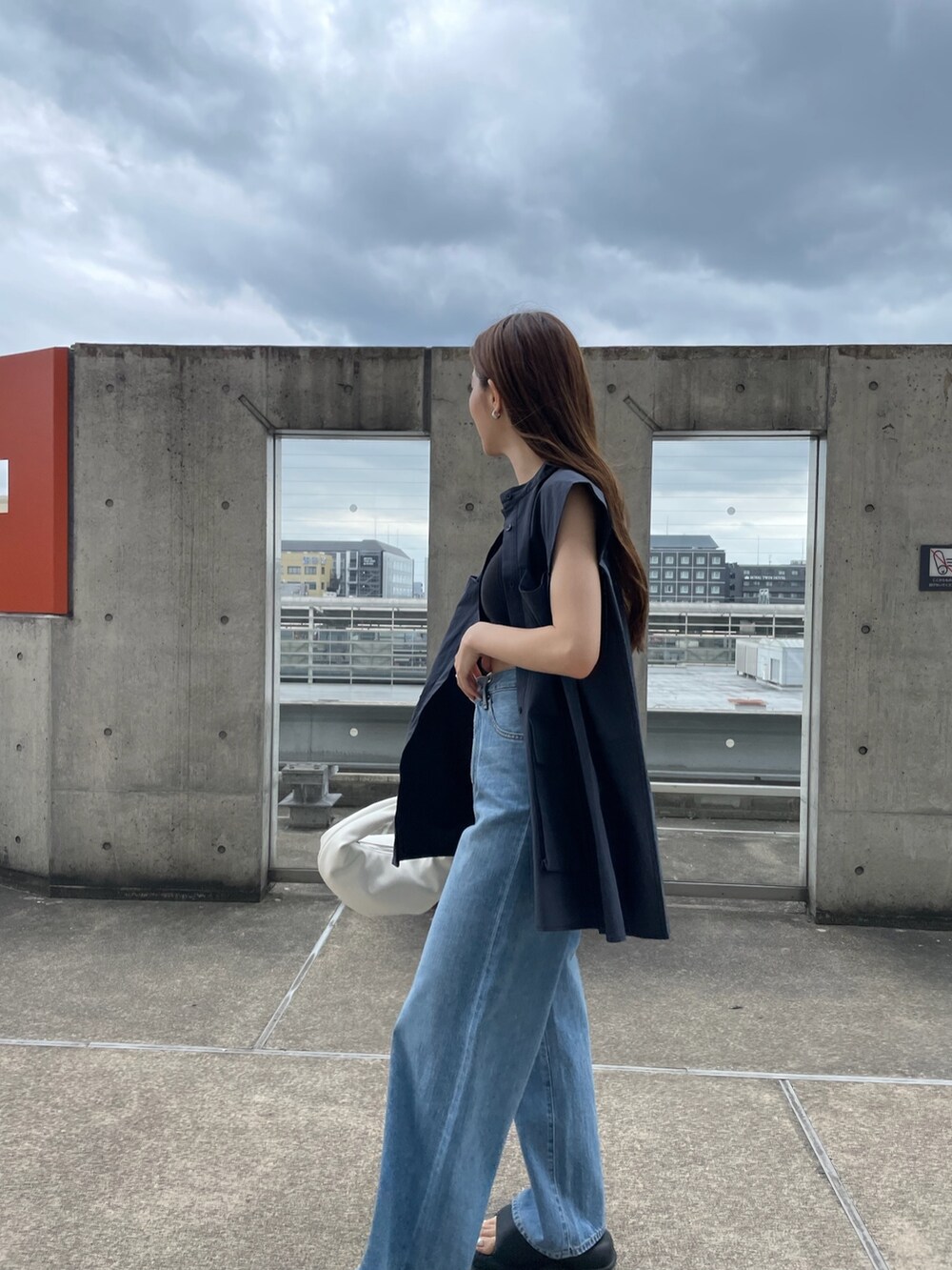 ブルー系のシャツ/ブラウス、ブラック系のキャミソール、ブルー系のデニムパンツを着用したレディースの夏コーディネートの4枚目の写真