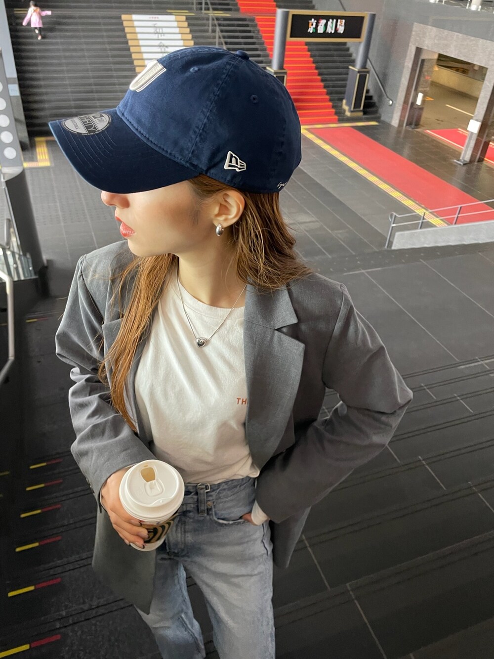 グレー系のテーラードジャケット、ホワイト系のTシャツ/カットソー、ブルー系のデニムパンツを着用したレディースの冬コーディネートの2枚目の写真