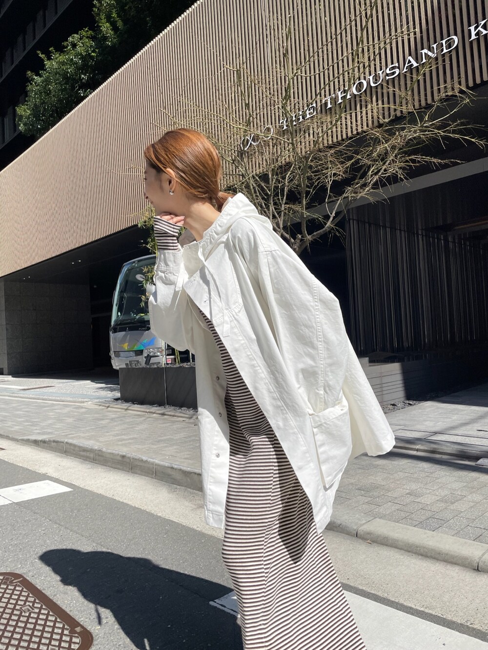 ホワイト系のブルゾン、ブラウン系のワンピースを着用したレディースの春コーディネートの2枚目の写真