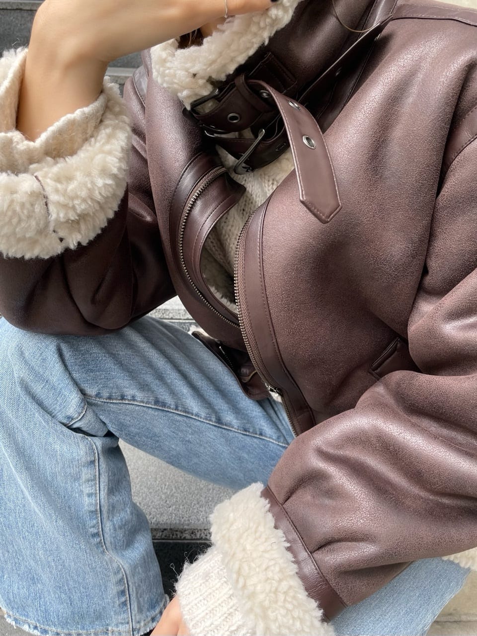 ブルー系のデニムパンツ、ブラウン系のムートンコート、ブルー系のデニムパンツを着用したレディースの秋コーディネートの6枚目の写真