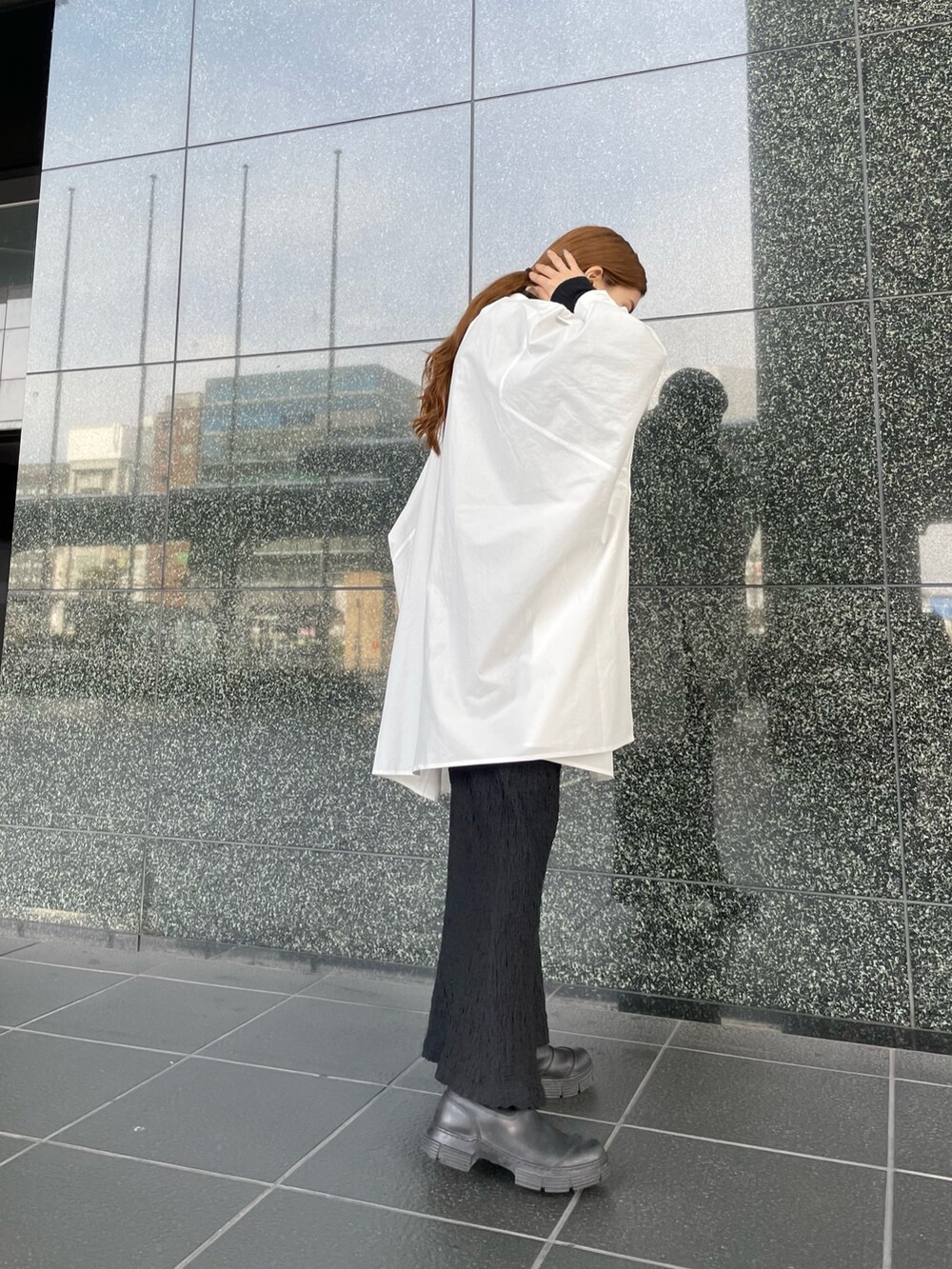 ブラック系のニット/セーター、ブラック系のスカート、ホワイト系のシャツ/ブラウスを着用したレディースの冬コーディネートの4枚目の写真