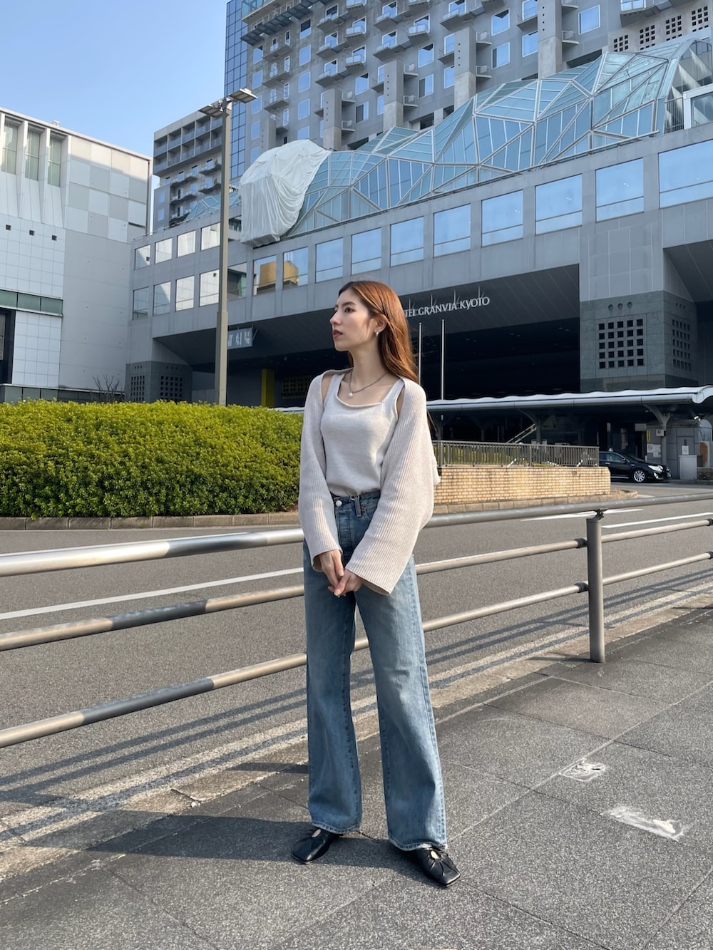 ブルー系のデニムパンツ、ブラック系のパンプス、ホワイト系のニット/セーターを着用したレディースの春コーディネートの4枚目の写真