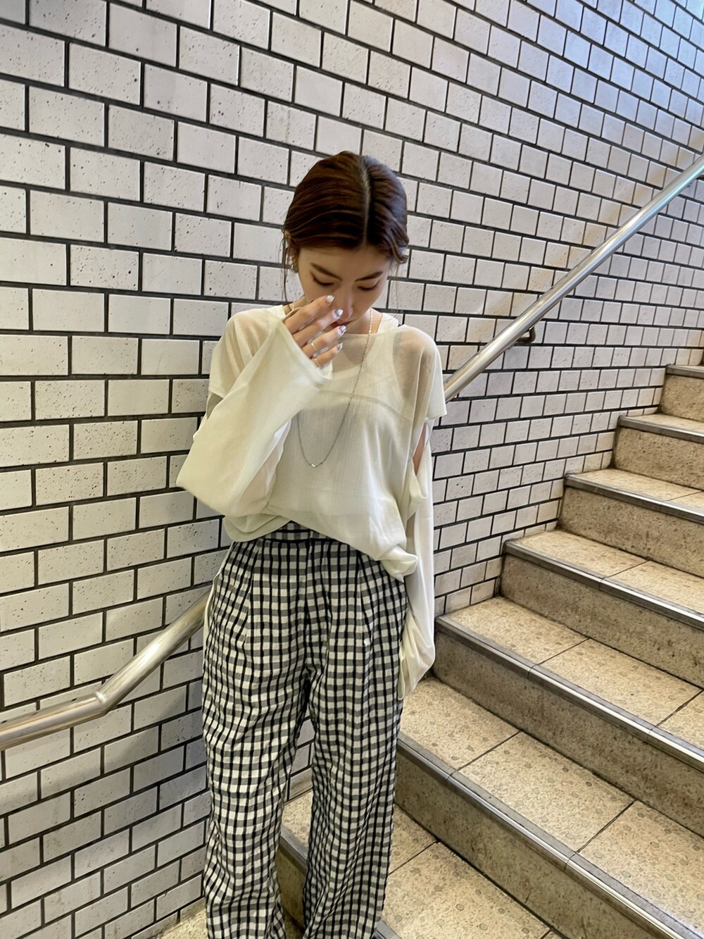 イエロー系のニット/セーター、ホワイト系のタンクトップ、グレー系のその他パンツを着用したレディースの冬コーディネートの4枚目の写真