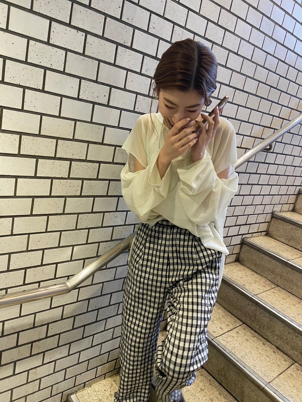 イエロー系のニット/セーター、ホワイト系のタンクトップ、グレー系のその他パンツを着用したレディースの冬コーディネートの2枚目の写真