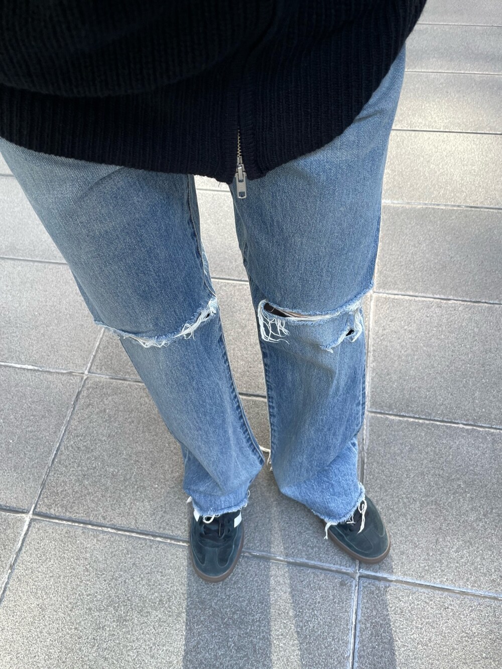 ブラック系のカーディガン/ボレロ、ブルー系のデニムパンツを着用したレディースの秋コーディネートの5枚目の写真