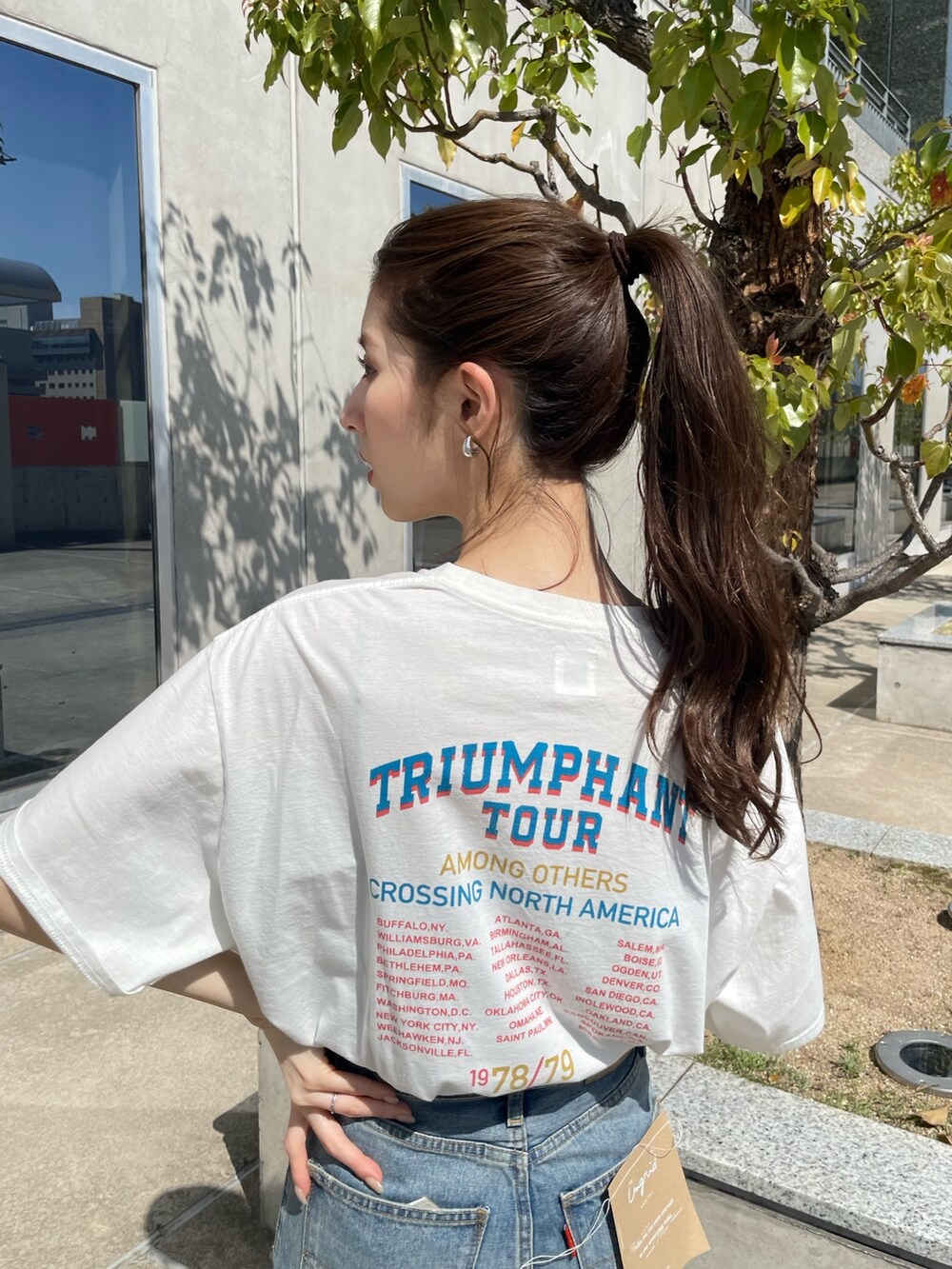 ホワイト系のTシャツ/カットソー、ブルー系のデニムパンツを着用したレディースの春コーディネートの3枚目の写真