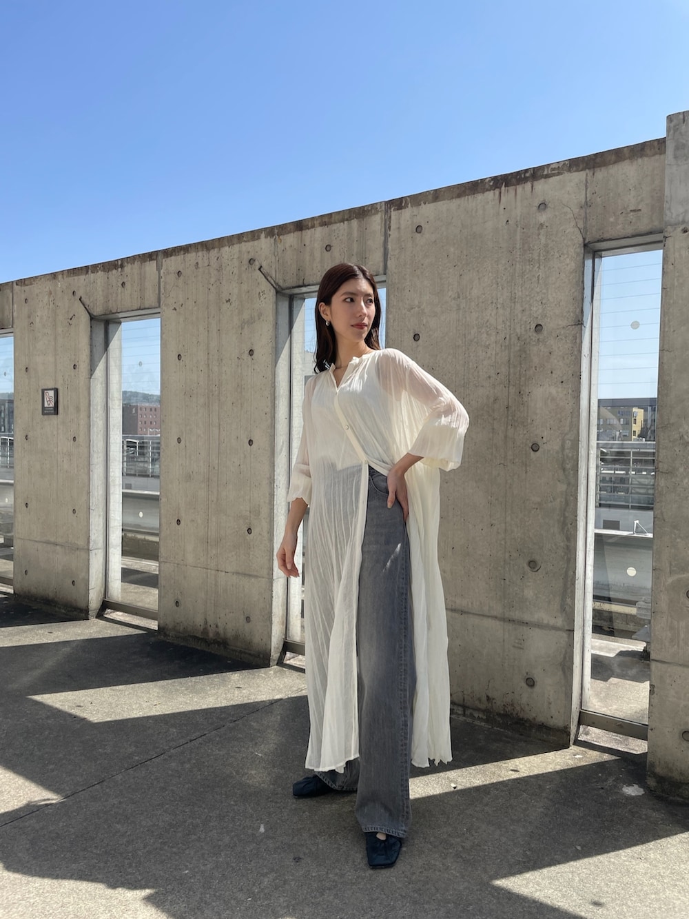 ホワイト系のワンピース、ホワイト系のタンクトップ、ブラック系のデニムパンツを着用したレディースの春コーディネートの3枚目の写真
