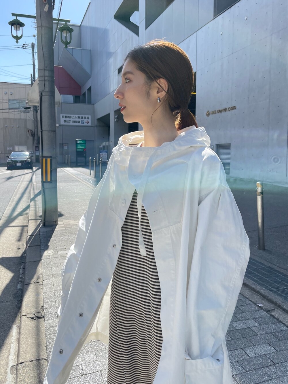 ホワイト系のブルゾン、ブラウン系のワンピースを着用したレディースの春コーディネートの4枚目の写真