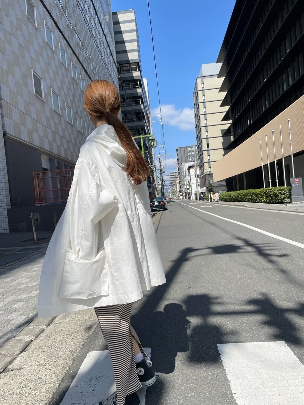 ホワイト系のブルゾン、ブラウン系のワンピースを着用したレディースの春コーディネートの3枚目の写真