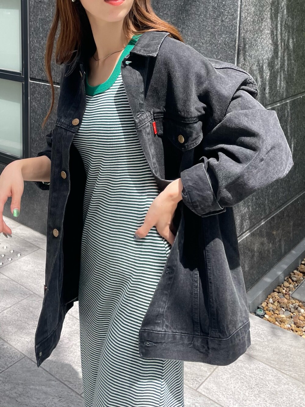 ブラック系のデニムジャケット、グリーン系のワンピースを着用したレディースの夏コーディネートの4枚目の写真