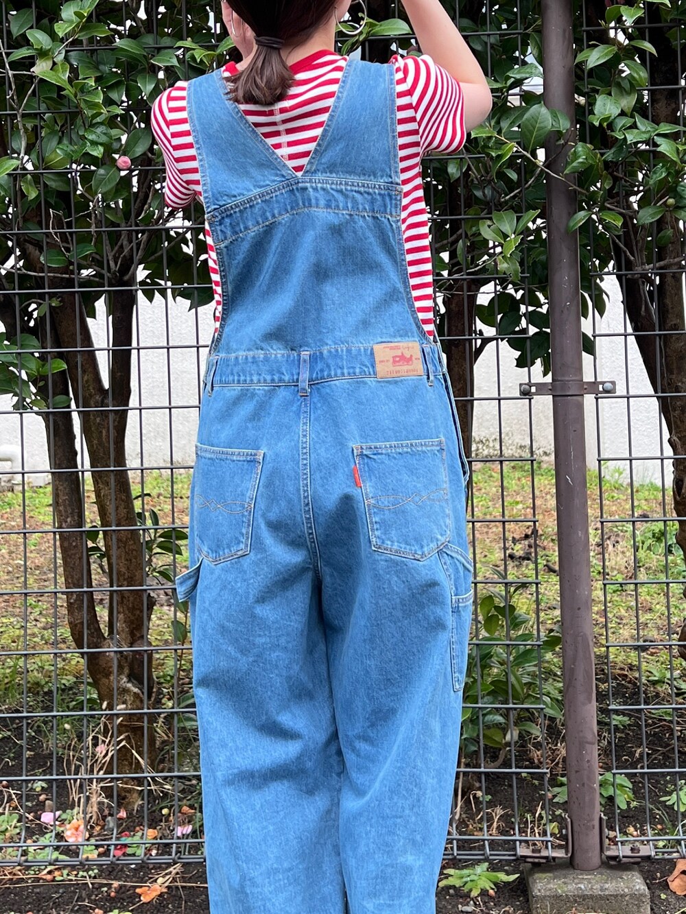 ブラック系のサンダル、ブルー系のつなぎ/オールインワン、レッド系のTシャツ/カットソーを着用したレディースの春コーディネートの7枚目の写真
