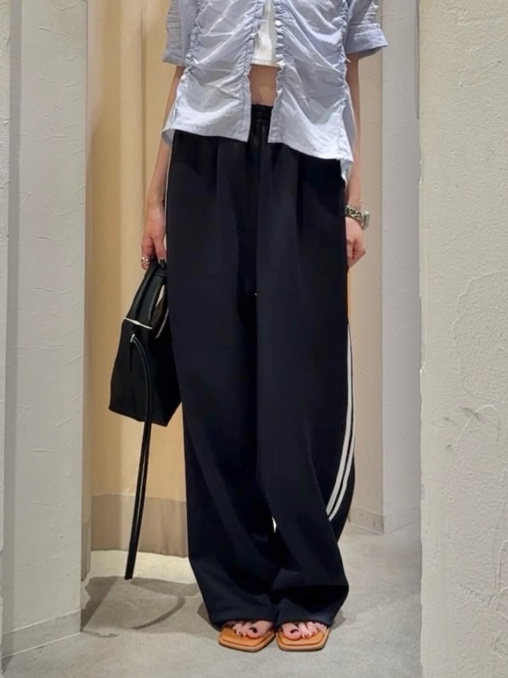 その他のサンダル、ブラック系のハンドバッグ、ブルー系のその他パンツを着用したレディースの夏コーディネートの6枚目の写真