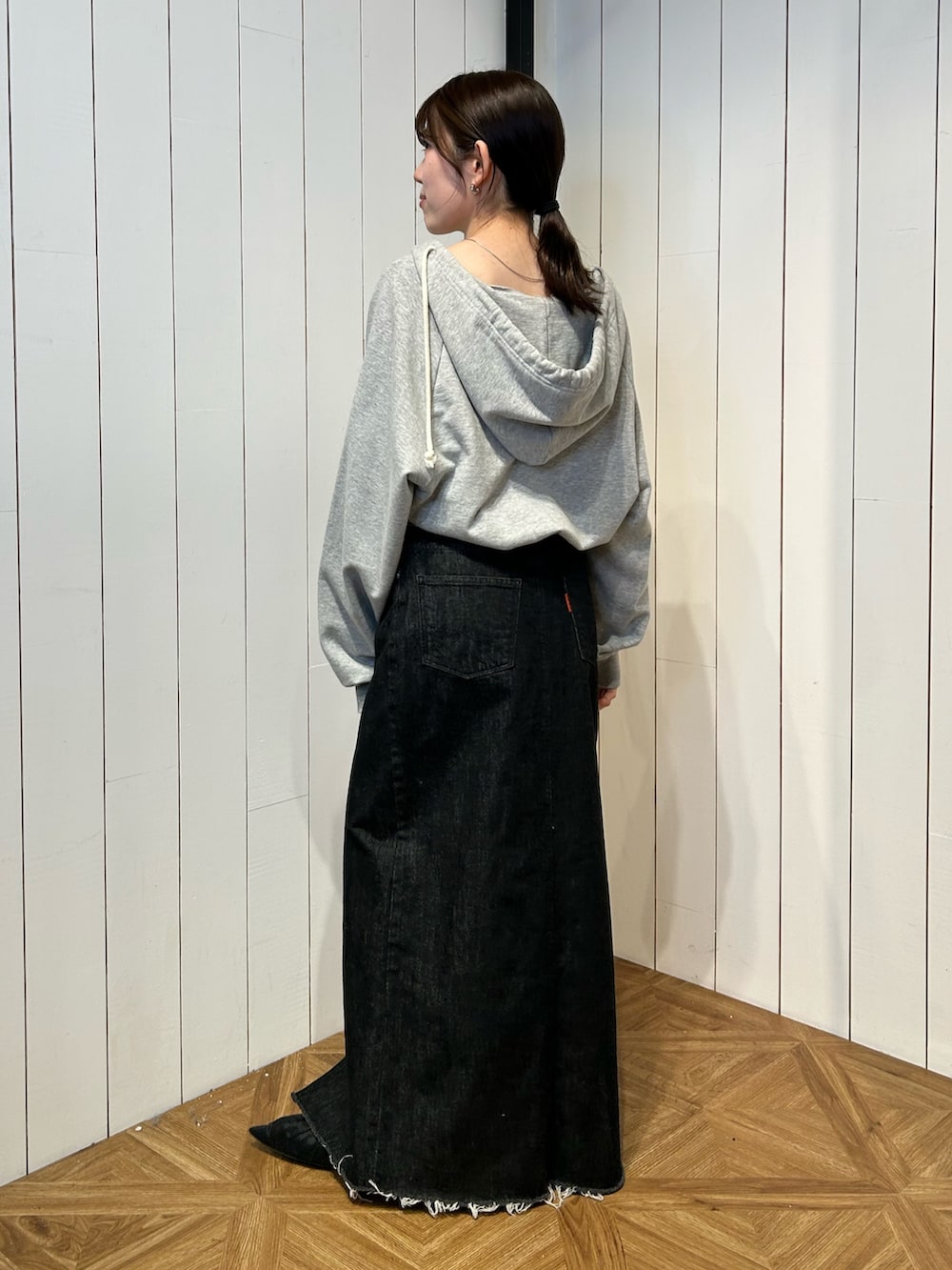 ブラック系のパンプス、ブラック系のスカート、グレー系のパーカーを着用したレディースの春コーディネートの4枚目の写真