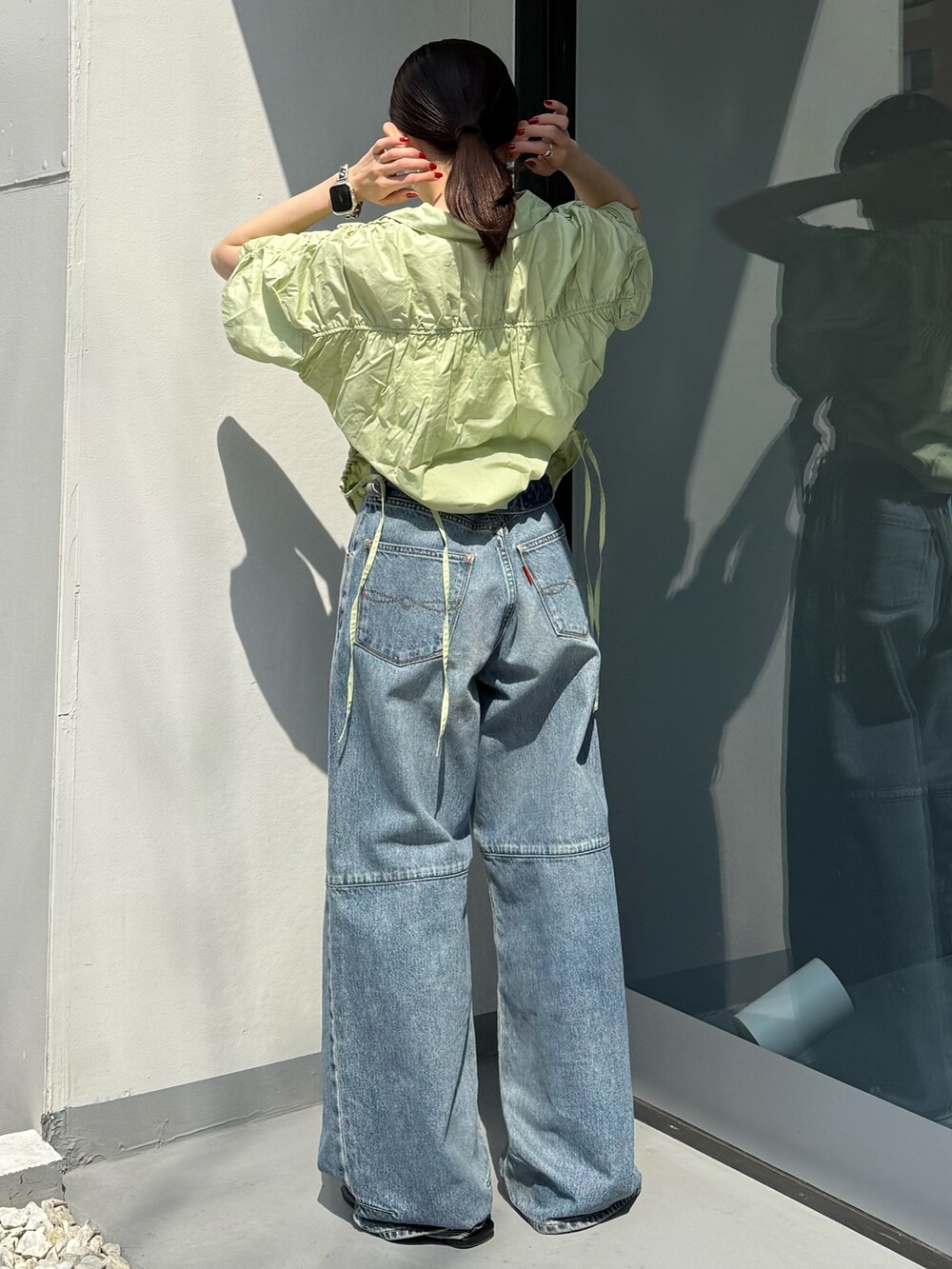 ブラック系のサンダル、ブルー系のデニムパンツ、グリーン系のシャツ/ブラウスを着用したレディースの春コーディネートの4枚目の写真