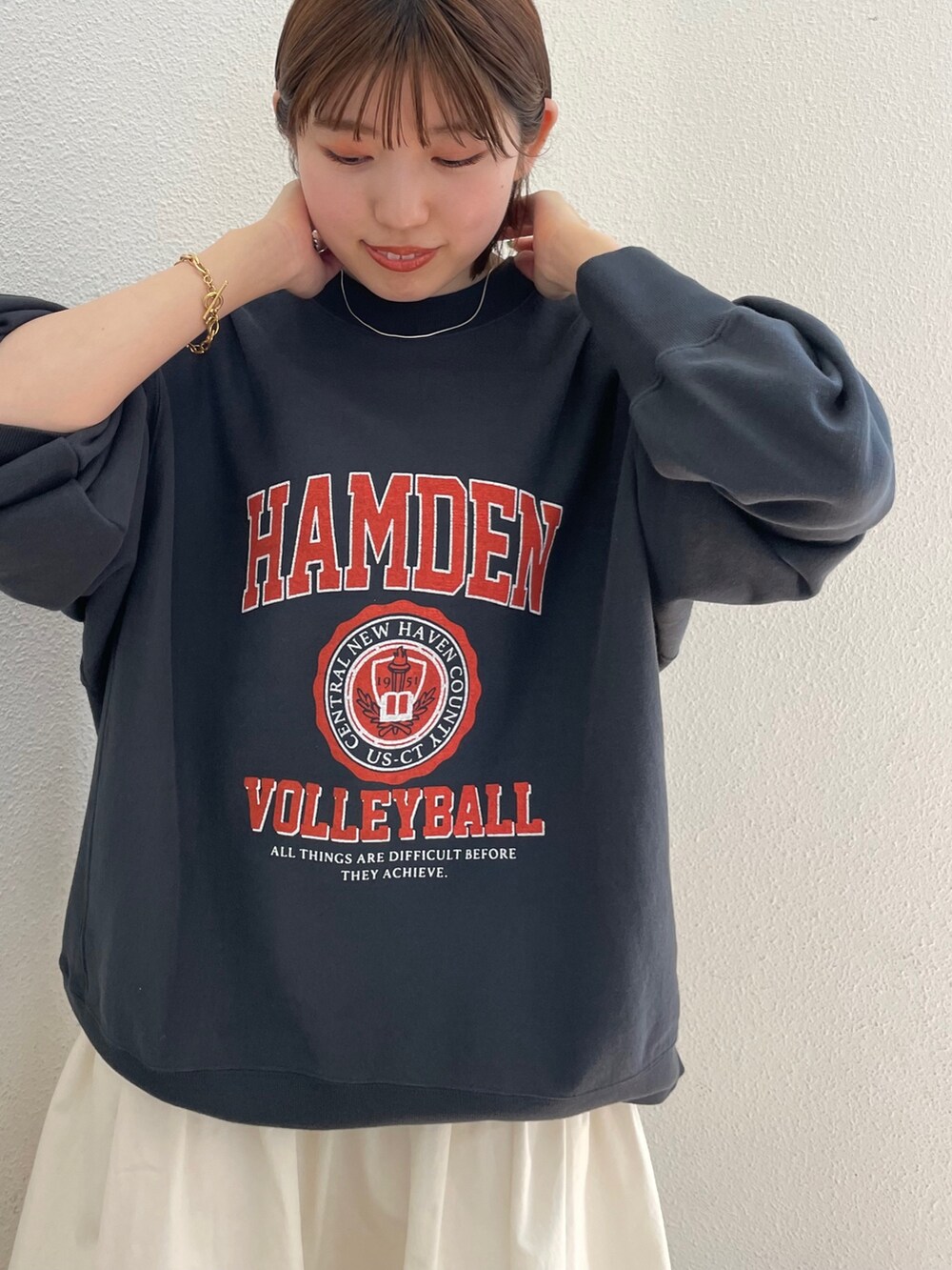 グレー系のスウェット、ホワイト系のスカート、グリーン系のスニーカーを着用したレディースの夏コーディネートの6枚目の写真