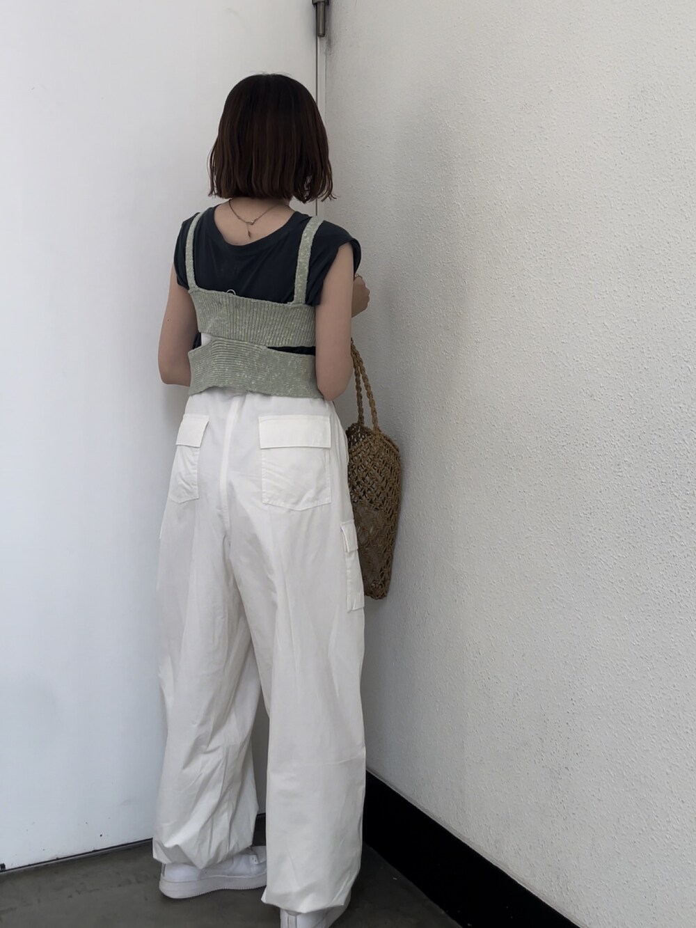ホワイト系のカーゴパンツ、グリーン系のニット/セーター、グレー系のタンクトップを着用したレディースの春コーディネートの4枚目の写真