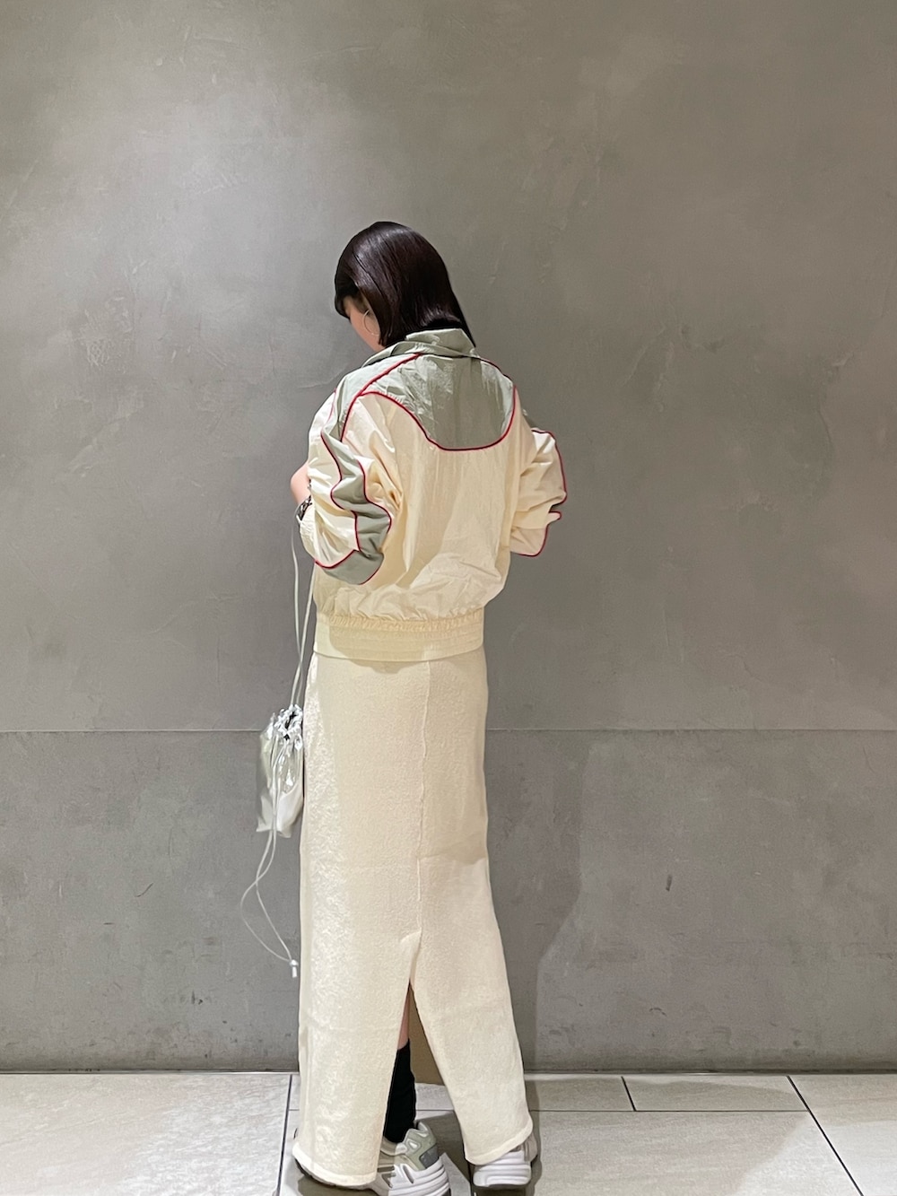 ホワイト系のスカート、ホワイト系のブルゾンを着用したレディースの冬コーディネートの5枚目の写真