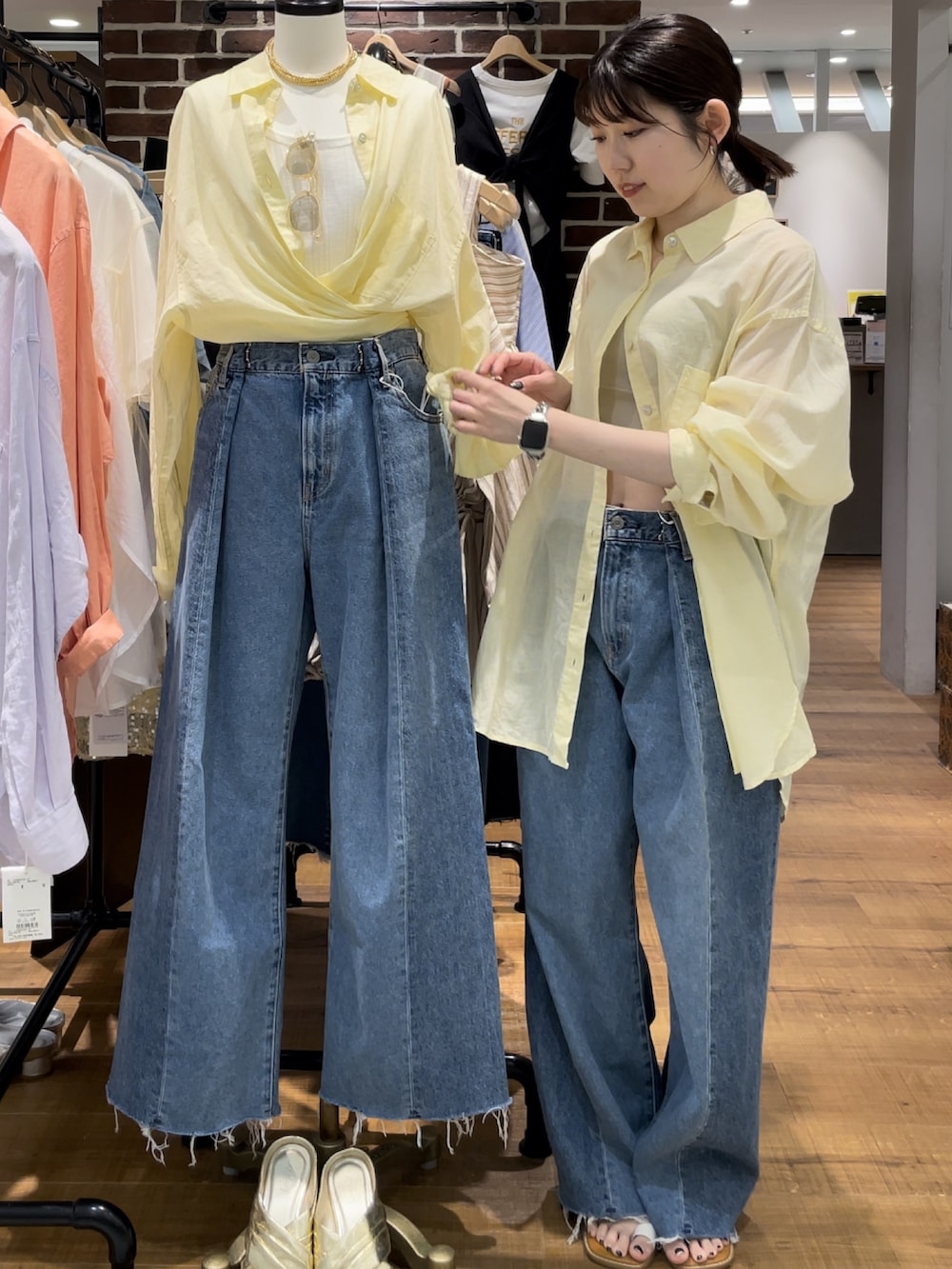 ブルー系のデニムパンツ、グレー系のキャミソール、ホワイト系のサンダルを着用したレディースの春コーディネートの2枚目の写真