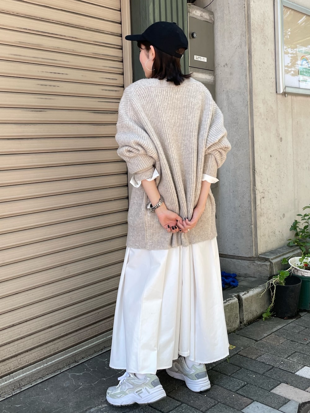 ホワイト系のカーディガン/ボレロ、ブラック系のワンピース、ブラック系のキャップを着用したレディースの秋コーディネートの3枚目の写真