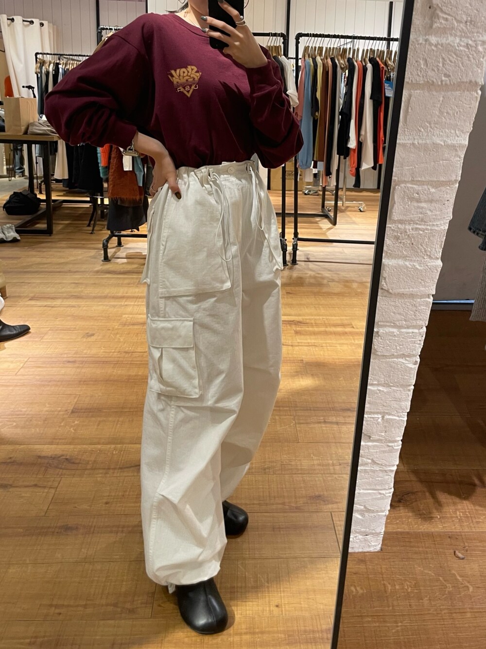 ブラック系のブーツ、ホワイト系のカーゴパンツ、レッド系のTシャツ/カットソーを着用したレディースの秋コーディネートの2枚目の写真