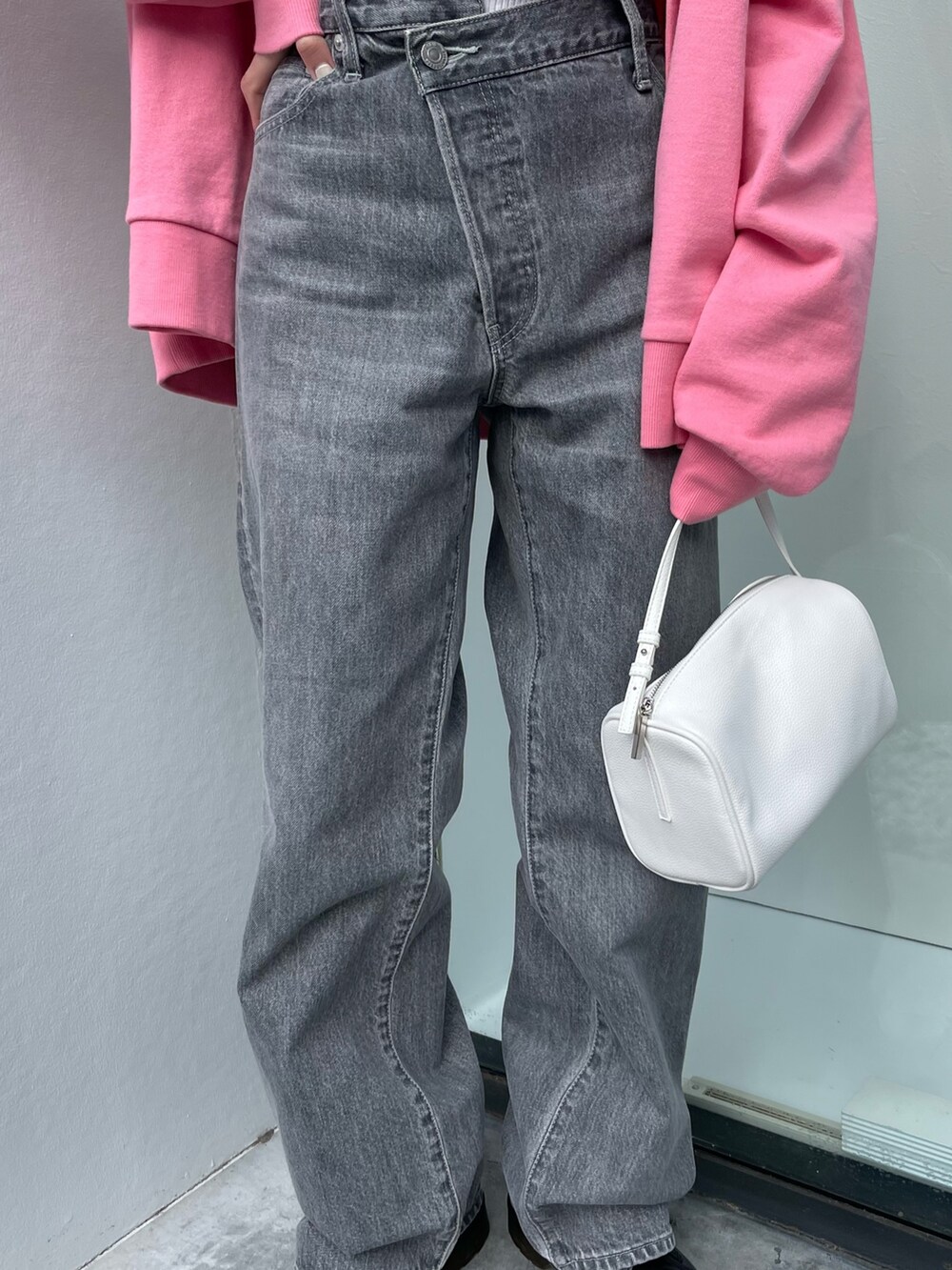 ピンク系のカーディガン/ボレロ、ホワイト系のハンドバッグ、ブラック系のデニムパンツを着用したレディースの冬コーディネートの5枚目の写真